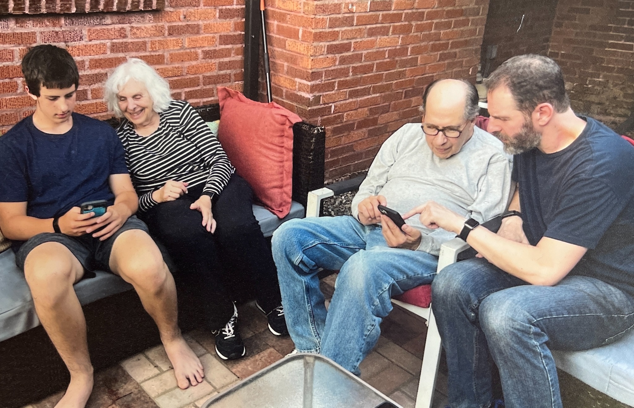 A family sitting together using phones and tablets